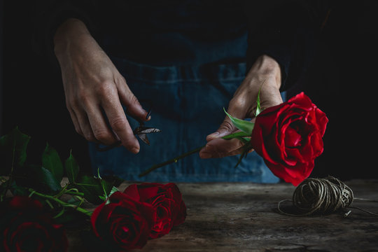 Midsection of woman making bouquet of red roses for Valentine's Day