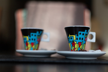 Dwie kolorowe filiżanki espresso na rozmytym tle - obrazy, fototapety, plakaty