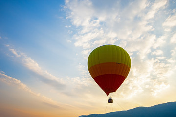 Hot air balloon over the green paddy field. Composition of nature and blue sky background