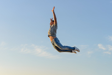 young man in a jump against a blue sky