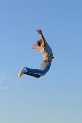 Obraz premium young man in a jump against a blue sky