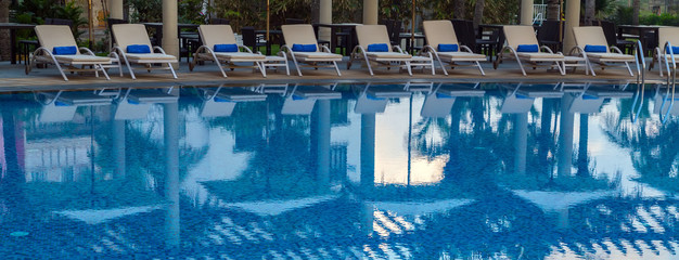 Fototapeta na wymiar Swimming pool rattan chairs hotel