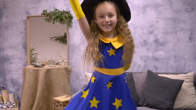 Stargazer girl dancing. Cute little girl in beautiful wizard dress with stars dancing holding magic stick.