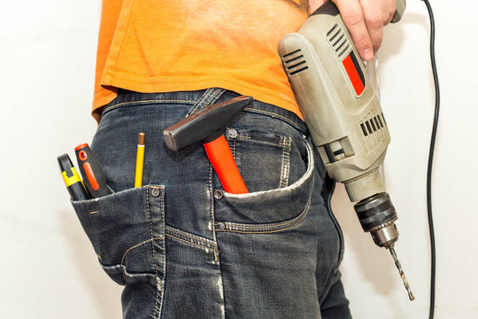 Engineering work tool in the back pocket of the jeans. pencil screwdriver hammer and utility knife