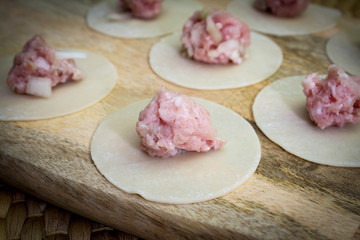 Raw dumplings, minced meat and dough on table
