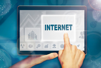 A hand selecting a Internet business concept on a computer tablet screen with a colorful background.