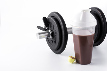 Chocolate protein shake and dumbbell isolated on white background. Copyspace