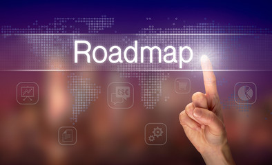 A hand selecting a Roadmap business concept on a clear screen with a colorful blurred background.
