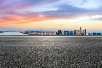 Empty asphalt road and city skyline at sunrise in hangzhou