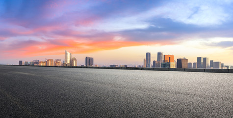 Empty asphalt road and city skyline at sunrise in hangzhou