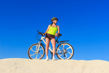 Fototapeta na wymiar Young beautiful woman with a sport bike, soft focus background