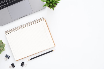 Creative flat lay photo of workspace desk. Top view office desk with laptop, pencil, notebook and plant on white color background. Top view with copy space, flat lay photography.