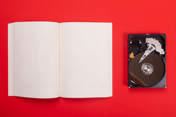 Noteboook and cassette isolated on red background
