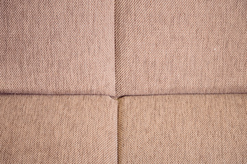 Fototapeta premium A close-up of a fragment of an expensive beige textile sofa in the room