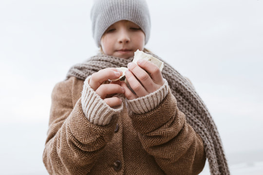Boy's hands holding cuttlebone on the beach in winter