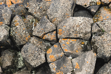 Textured basalt background hexagonal stone pillars in a section. natural volcanic formations