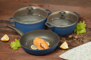 Aluminum non-stick cookware with vegetables on wooden background