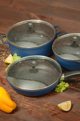 Aluminum non-stick cookware with vegetables on wooden background