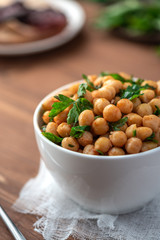 Cooked chickpeas with parsley and paprika in a white bowl. Vegetarian food.