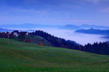 Landscape in Slovenia, nature in Europe.  Foggy Triglav Alps with forest, travel in Slovenia. Beautiful sunrise with blue sky, green nature.
