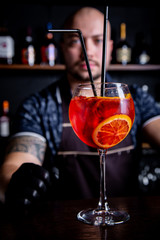 Barman gives prepared cocktail of fresh and tasty Aperol syringe