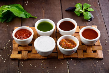 different sauces on wooden background
