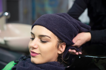 young woman in hairdresser salon, towel on head