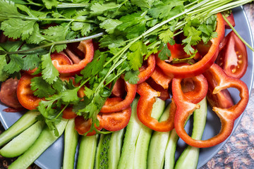 Cut cucumbers and tomatoes pepper parsley on table