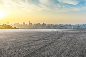 Panoramic city skyline and buildings with empty asphalt road at sunrise