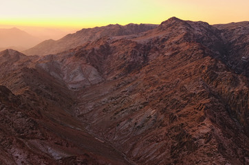 Scenic landscape in the mountains at sunrise. Amazing view from Mount Sinai (Mount Horeb, Gabal Musa, Moses Mount). Sinai Peninsula of Egypt. Pilgrimage place and famous touristic destination