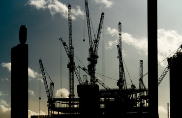 Multiple cranes on a building construction site in high contrast