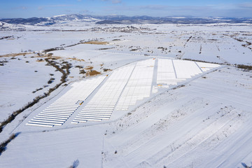 Aerial image of snow covered solar panel park