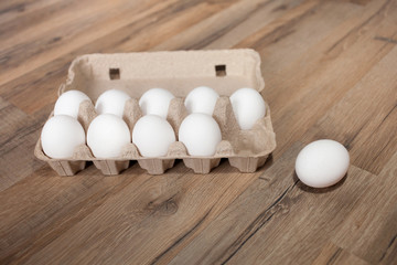 ten eggs in an egg carton on wooden table. The concept of economics and finance, shrinkflation. Easter.