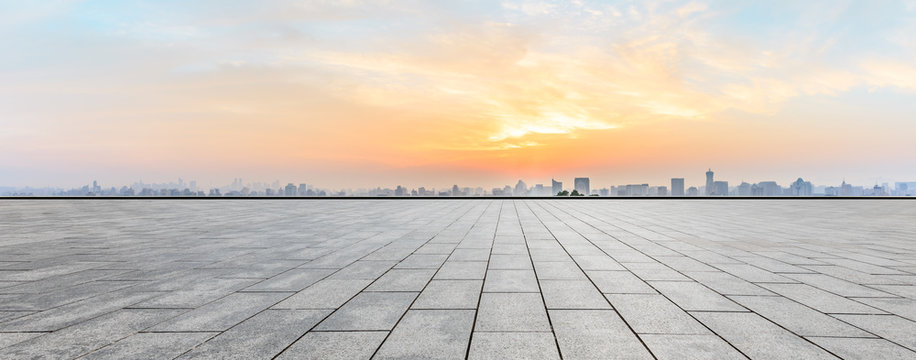 Panoramic city skyline and buildings with empty square floor at sunrise