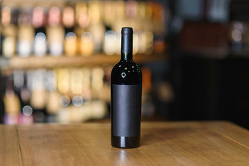 bottle with red wine on wooden table