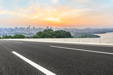 Fototapeta premium Panoramic city skyline and buildings with empty asphalt road at sunrise