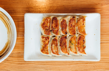 Top view of Yaki-Gyoza set (Japanese Pan-Fried Dumplings) served on white plate.
