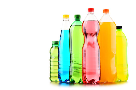Plastic bottles of assorted carbonated soft drinks over white