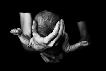 Tête d'un bébé tenu dans les mains de son père - photo noir et blanc