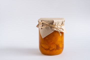Homemade Apricot jam in glass jar on white background. Copy space