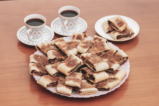 cookies on a plate and two cups of coffee