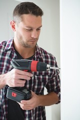 Male carpenter using drill machine