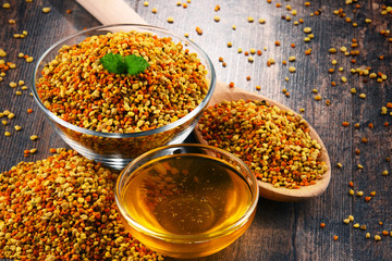 Bowls with bee pollen and honey on kitchen table
