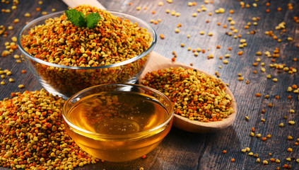 Bowls with bee pollen and honey on kitchen table