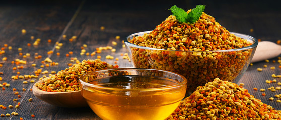 Bowls with bee pollen and honey on kitchen table