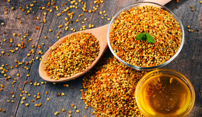 Bowls with bee pollen and honey on kitchen table