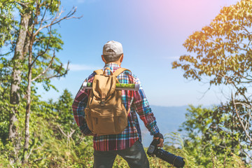 Nature photographer take photos with mirror camera on peak of mountain.