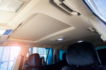 Light beige ceiling in the cabin of the SUV after dry cleaning and seasonal inspection in the...