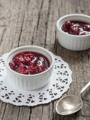 Homemade strawberry sweet tasty jam with whole berries on wooden background