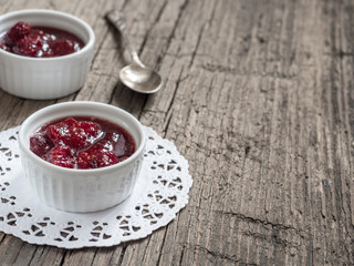 Homemade strawberry sweet tasty jam with whole berries on wooden background